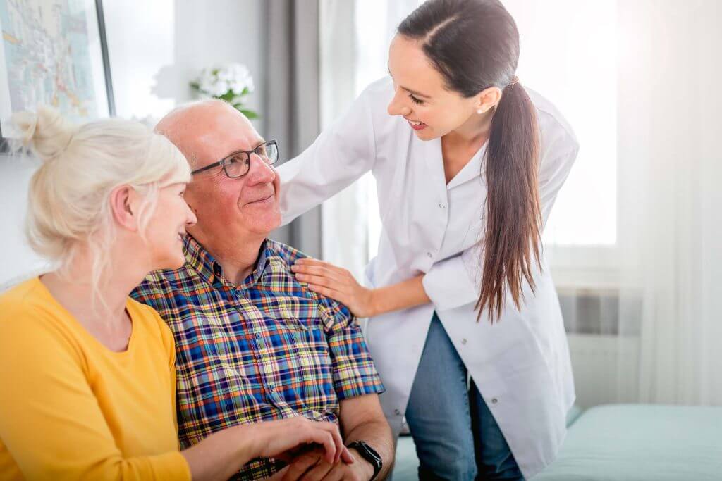 smiling-nurse-talking-with-senior-couple